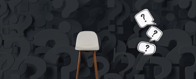 A chair with wooden legs on a gray background full of question marks and an 'Exit' ad spotlit.